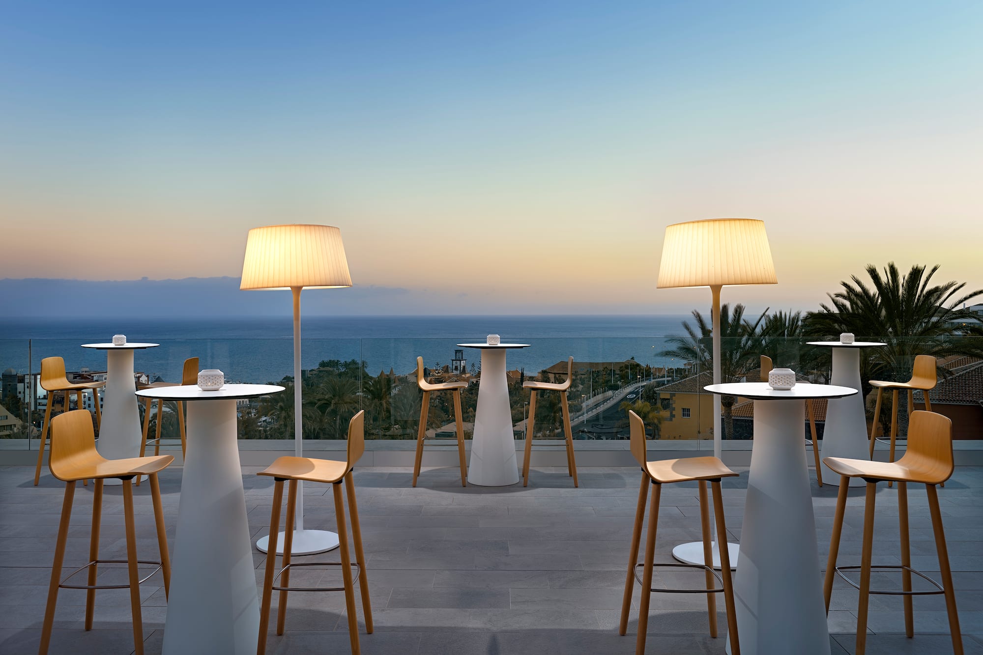 a group of tables and chairs with a view of the ocean