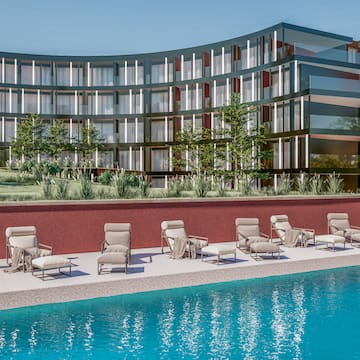 a pool with chairs and a building in the background