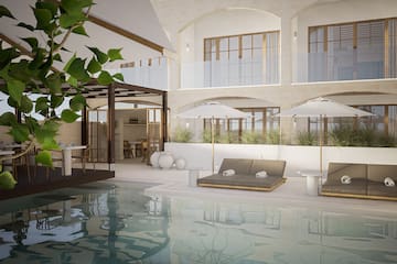 a pool with chairs and umbrellas in a building