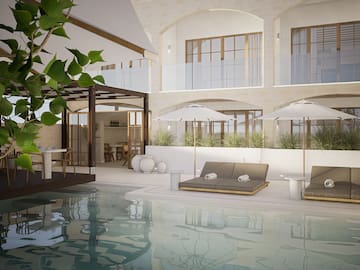 a pool with chairs and umbrellas in a building