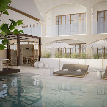 a pool with chairs and umbrellas in a building