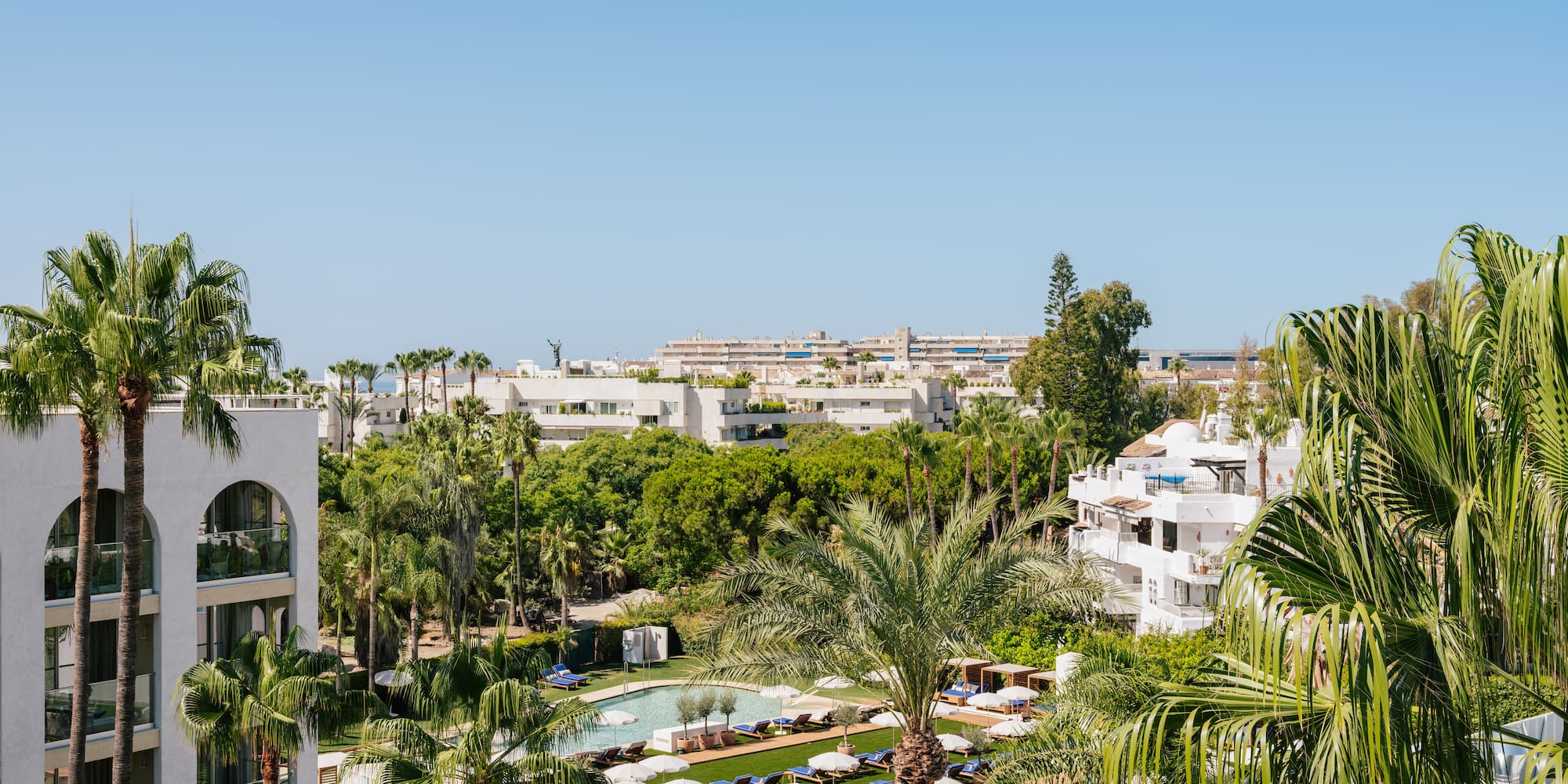 a pool area with palm trees and buildings