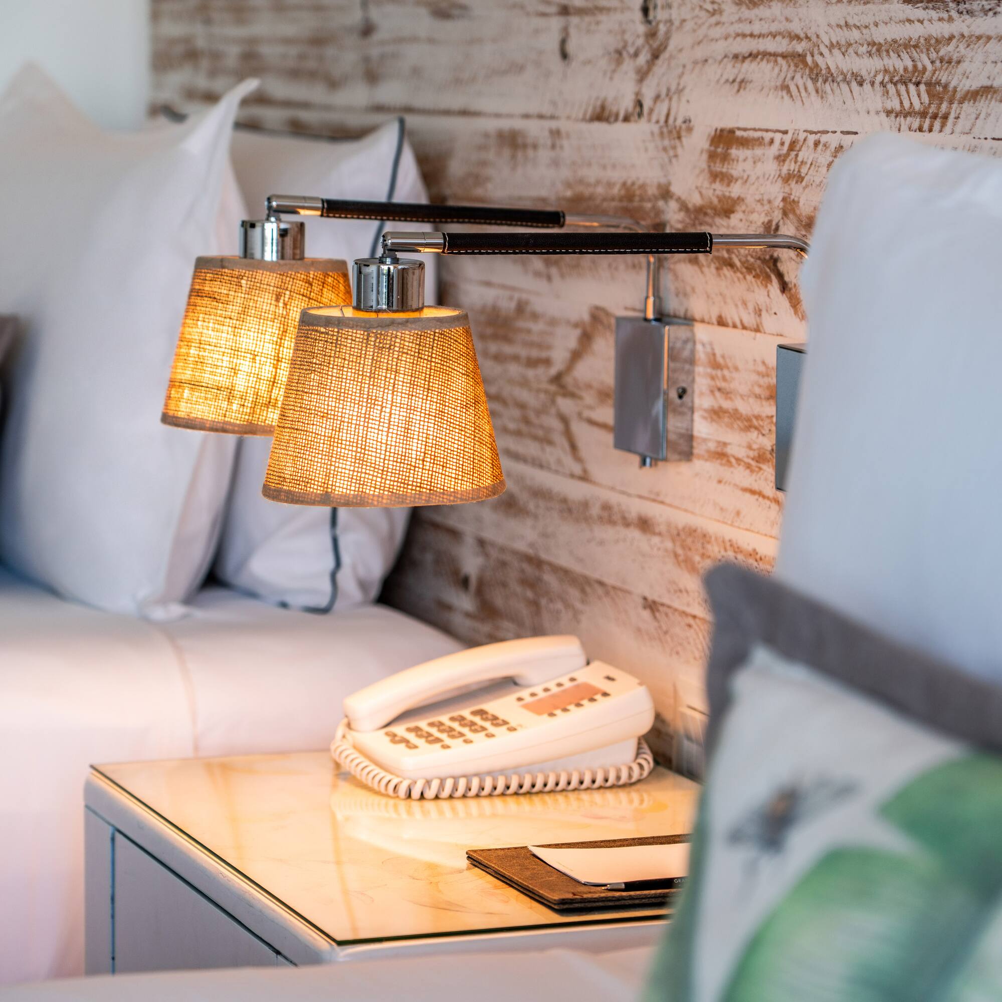 a lamp on a table next to a bed