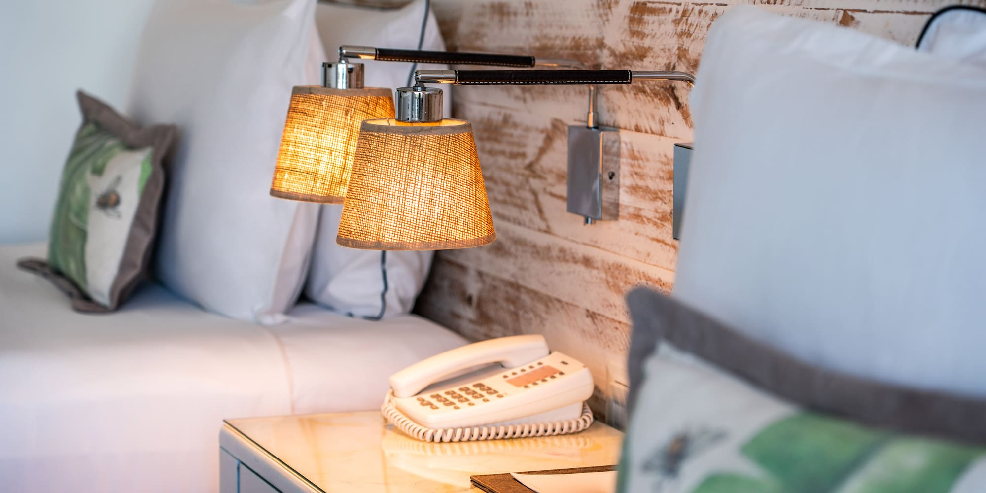 a lamp on a table next to a bed