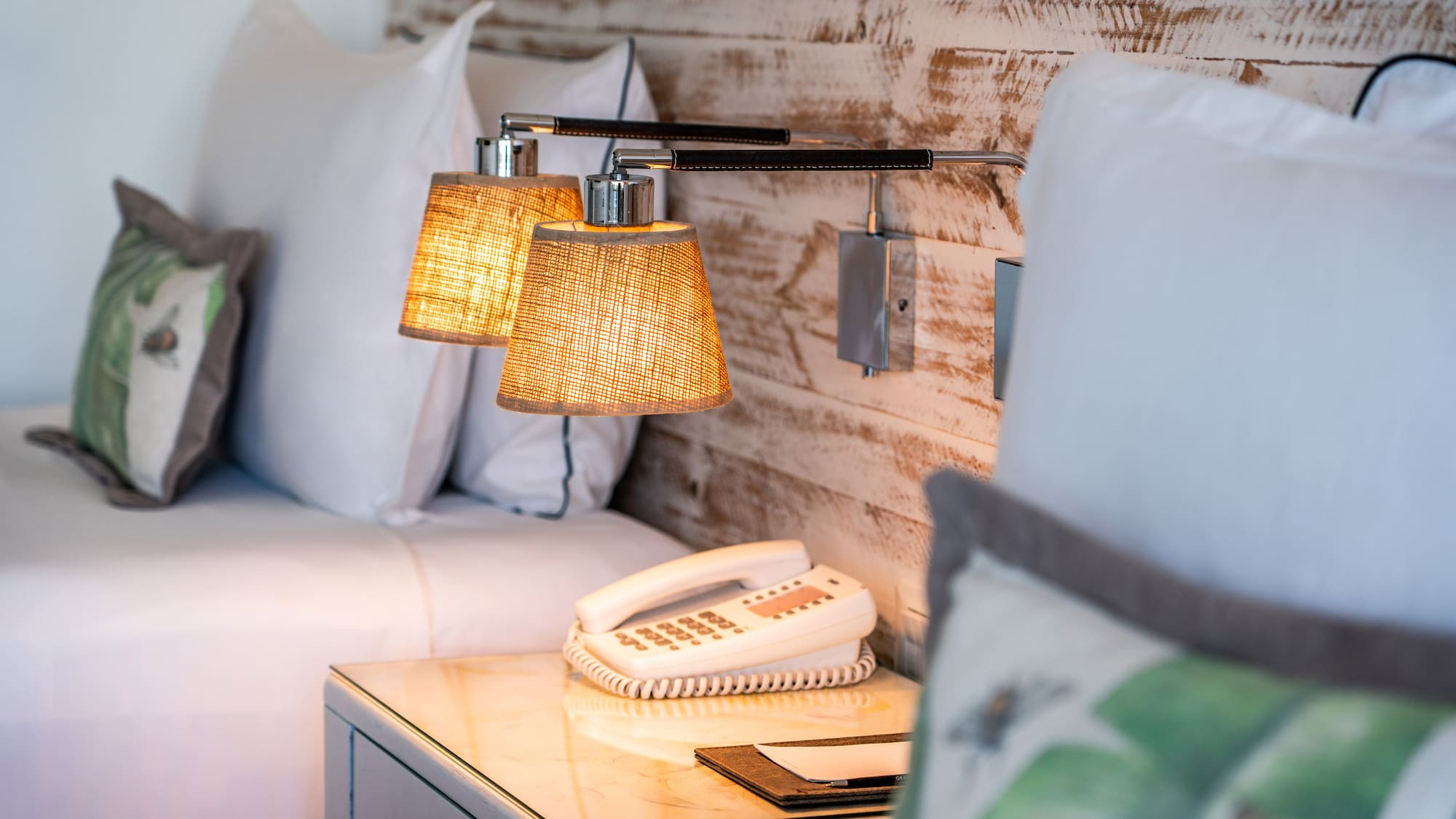 a lamp on a table next to a bed