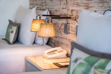 a lamp on a table next to a bed