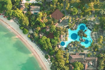 an aerial view of a resort with swimming pools and trees