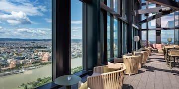 a room with chairs and tables and a view of a city