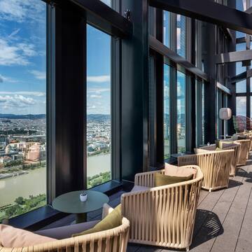 a room with chairs and tables and a view of a city