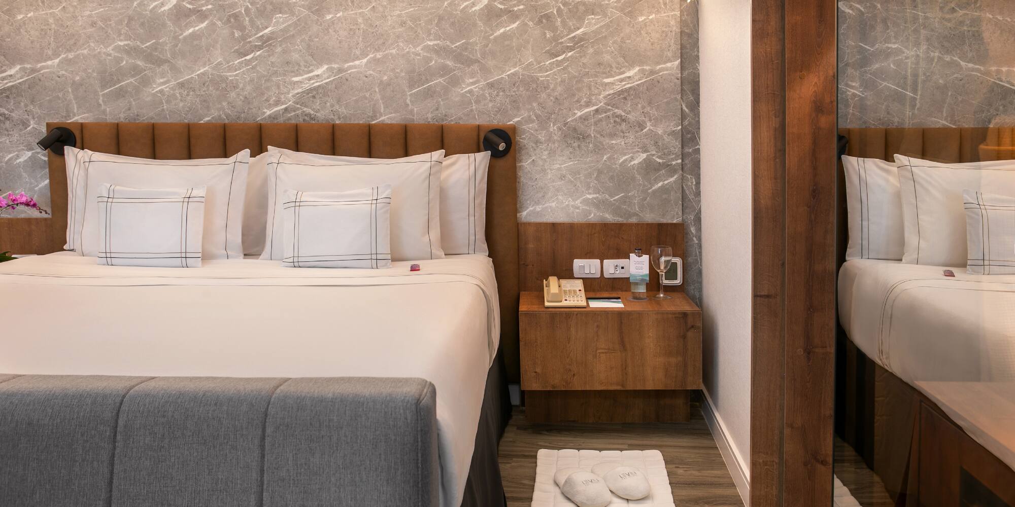 a bed with pillows and a rug on the floor