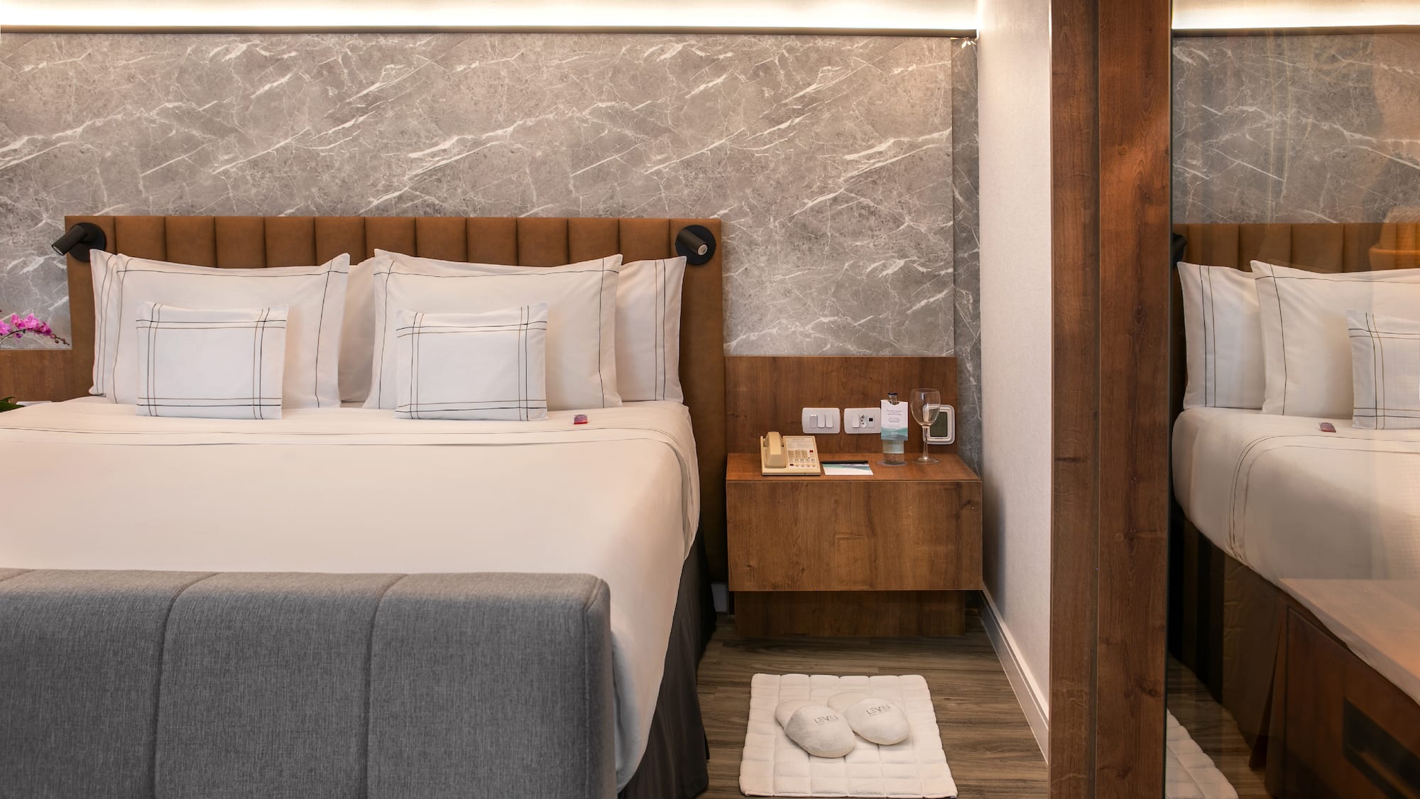 a bed with pillows and a rug on the floor