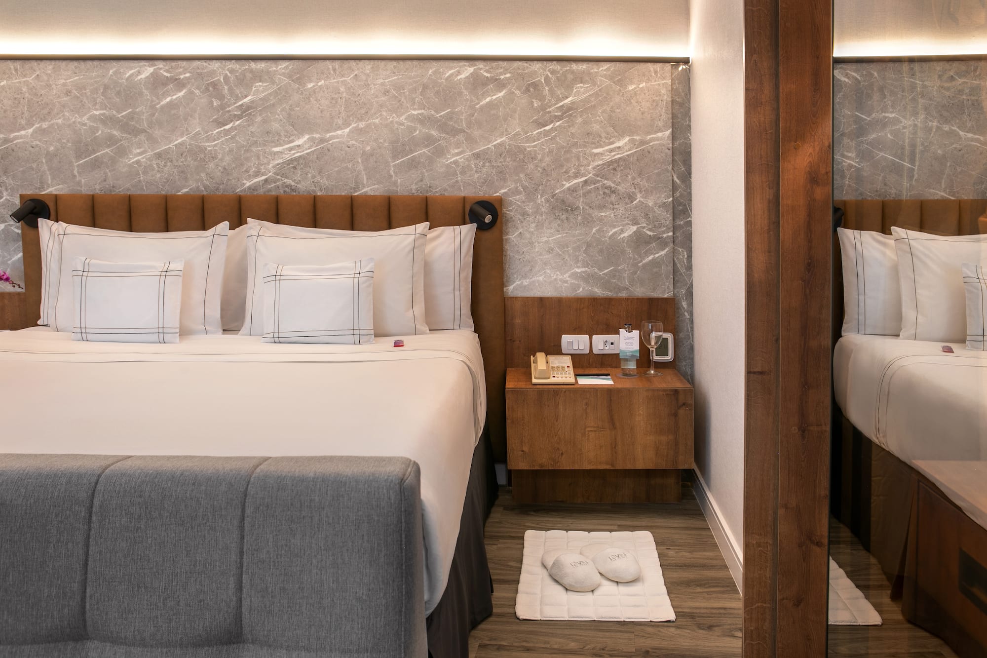 a bed with pillows and a rug on the floor