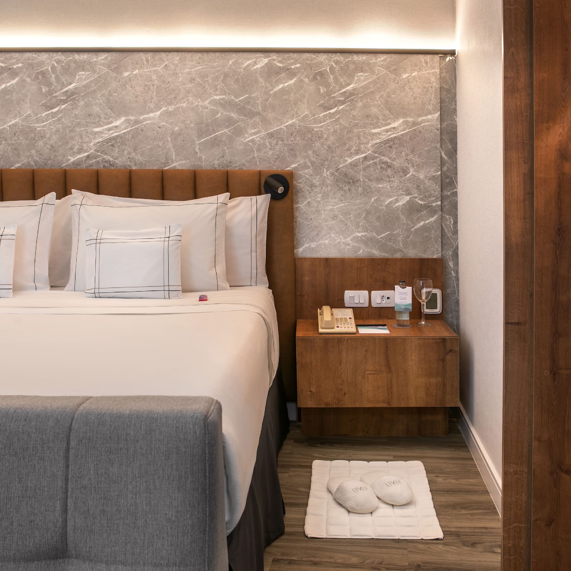 a bed with pillows and a rug on the floor