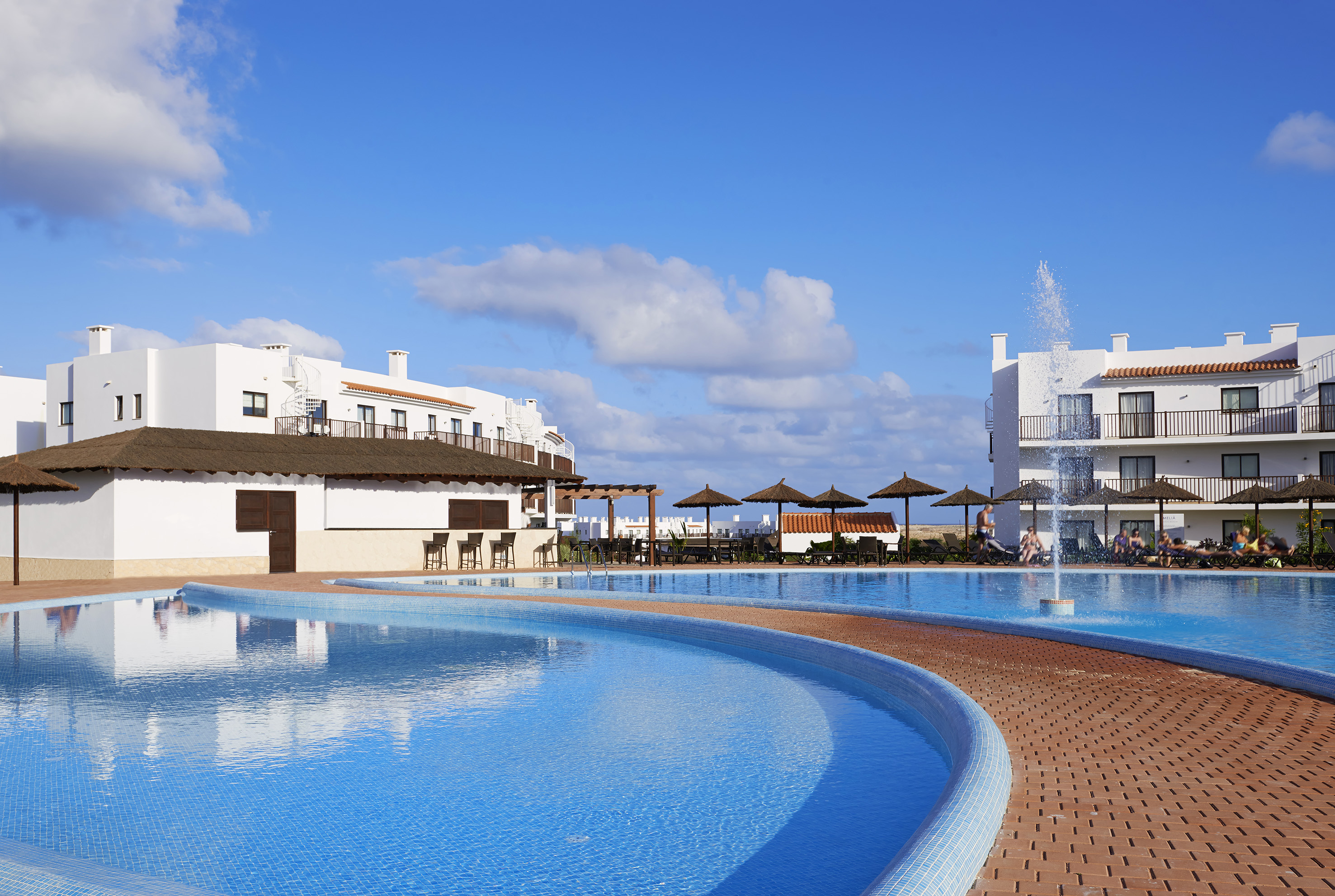 a pool with a fountain and buildings