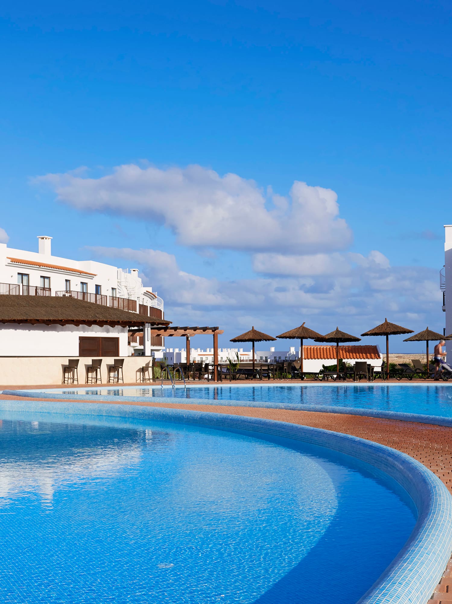 a pool with a fountain and buildings