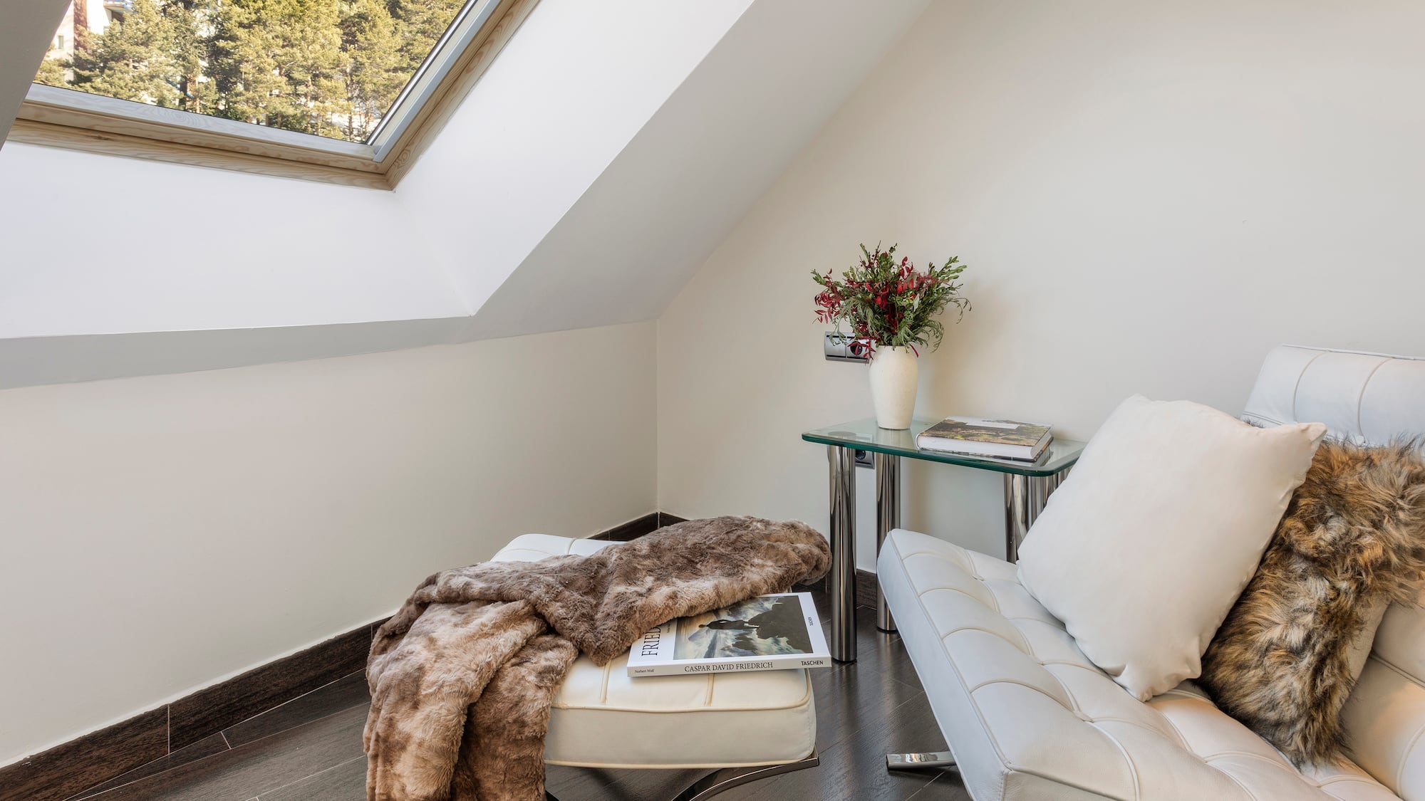 a white couch and a table in a room with a skylight