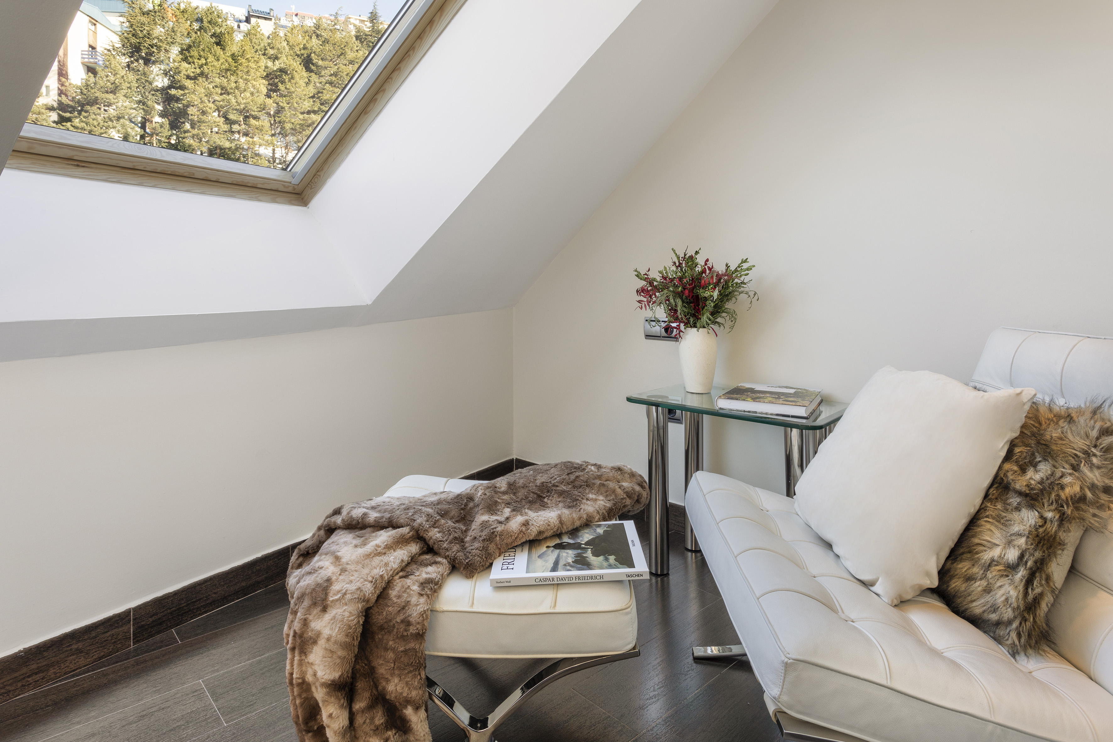 a white couch and a table in a room with a skylight