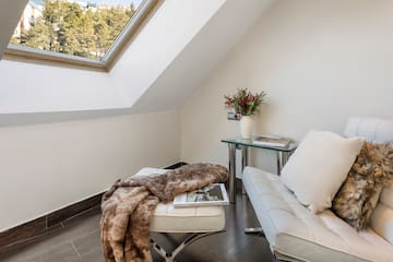 a white couch and a table in a room with a skylight
