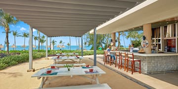 a group of people sitting at tables outside a restaurant