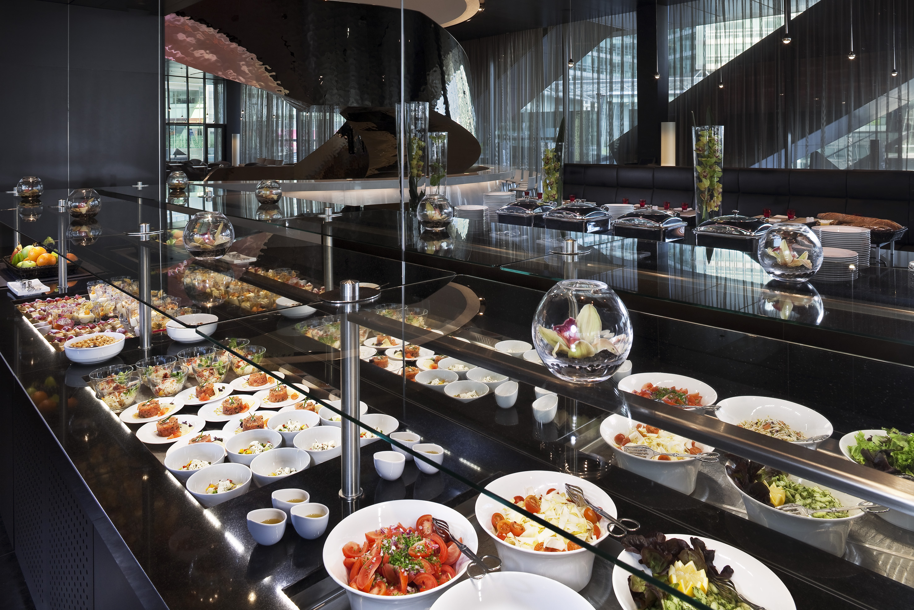 Modern restaurant buffet offering fresh salads, appetizers, and elegant desserts.
