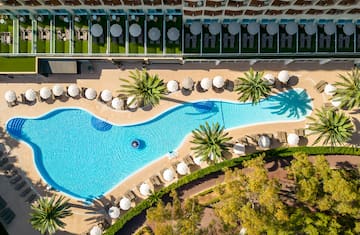 a swimming pool with umbrellas and palm trees