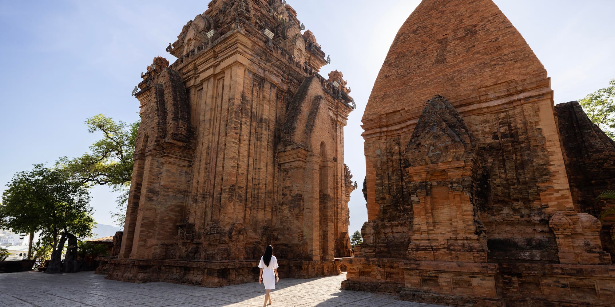 a woman walking in front of a brick structure
