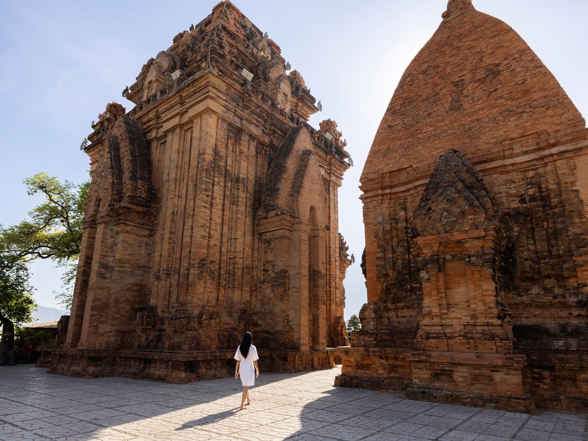 a woman walking in front of a brick structure