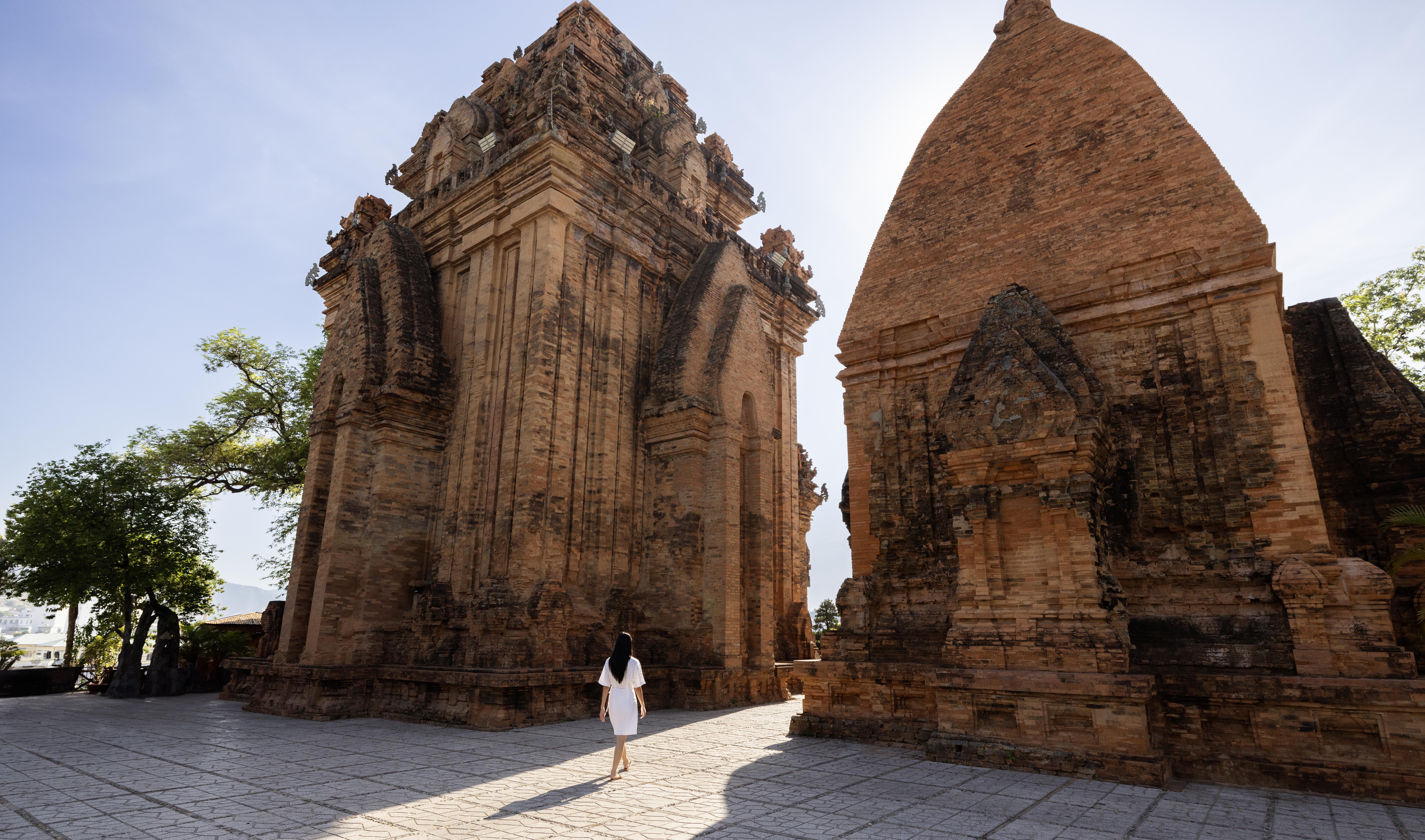 Woman exploring ancient Cham towers, historic site in Vietnam.