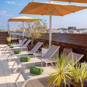 a deck with chairs and umbrellas on a rooftop