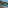Palm-lined beach, blue ocean, rocky cliff, and seaside restaurant.