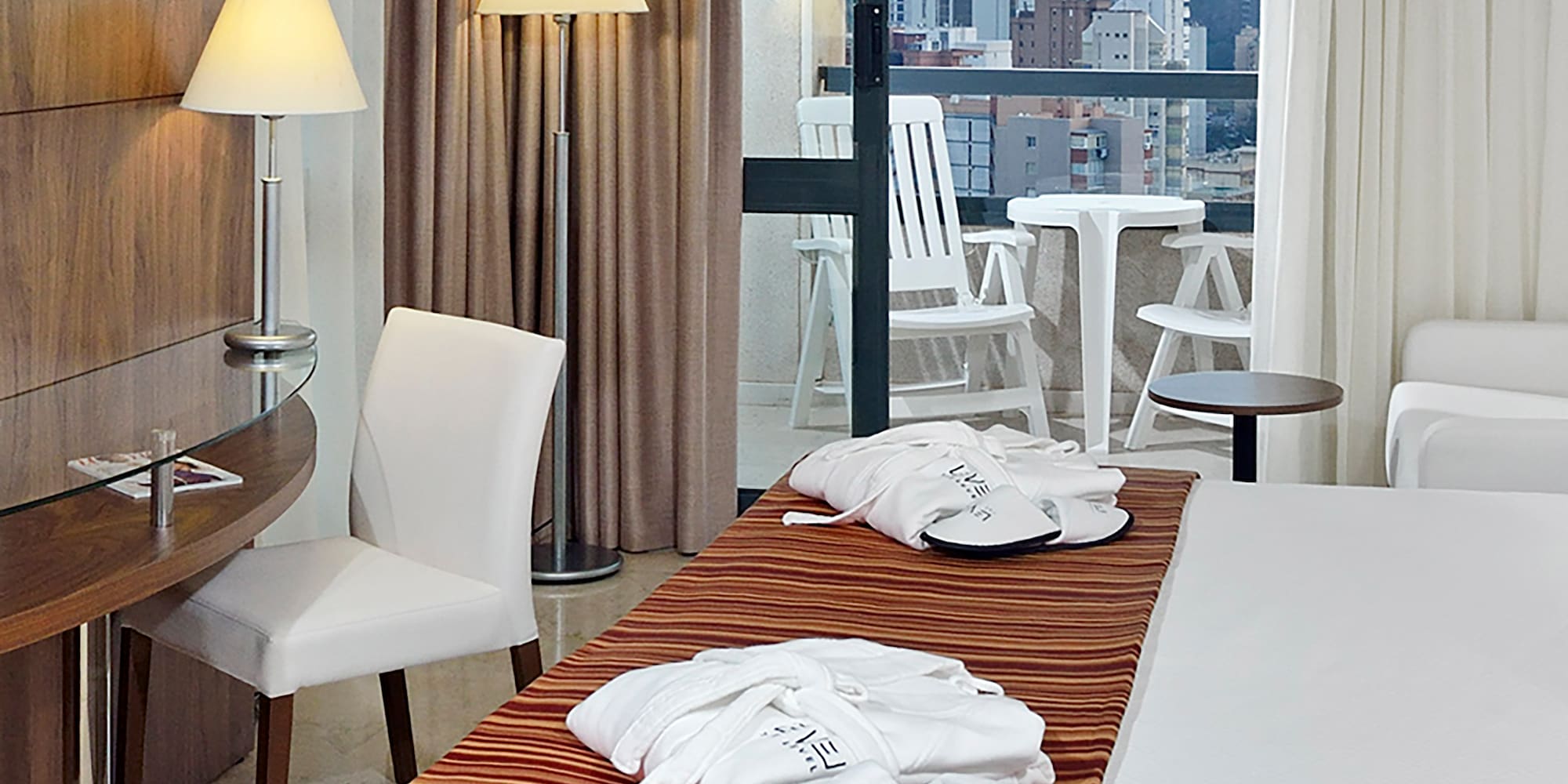 a hotel room with a bed and chairs