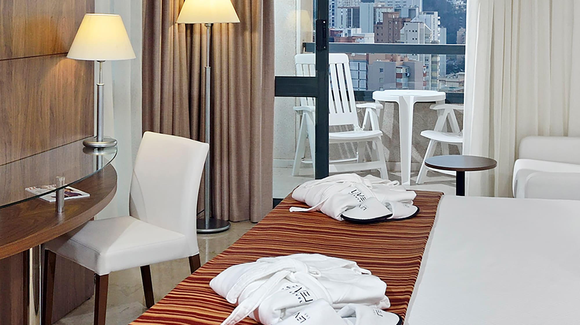 a hotel room with a bed and chairs