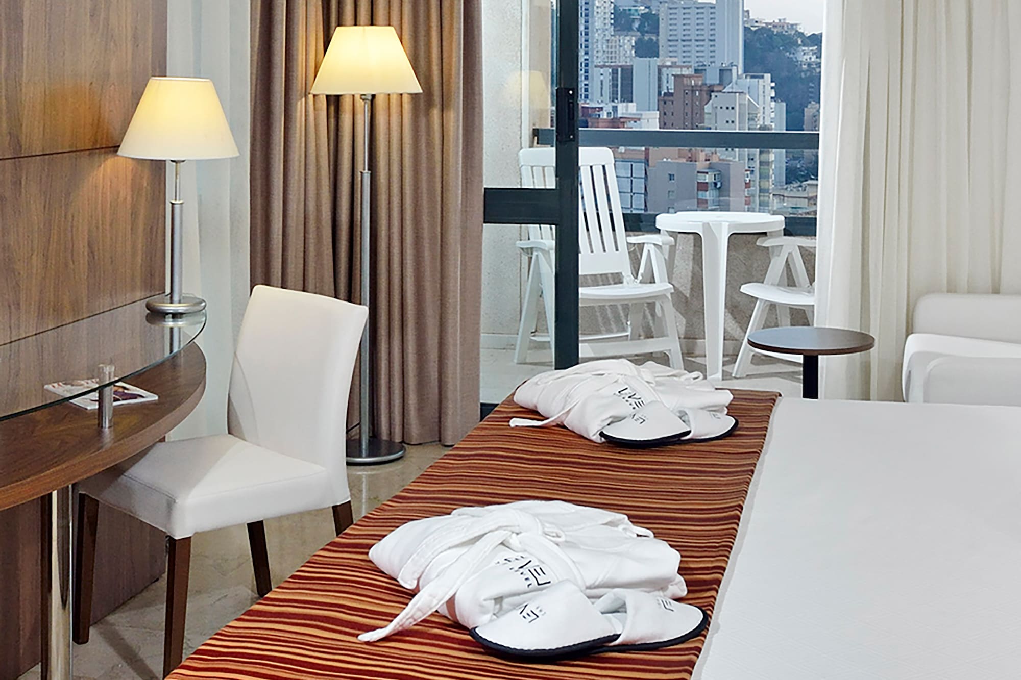 a hotel room with a bed and chairs