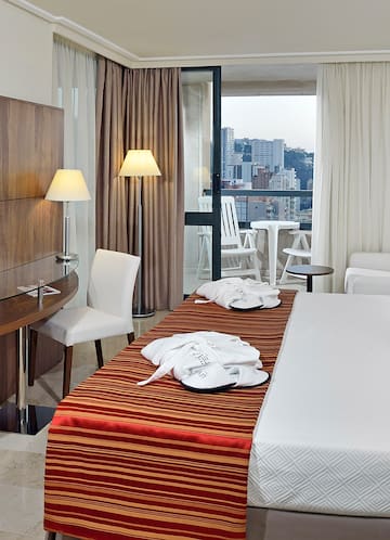 a hotel room with a bed and chairs
