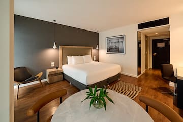 a room with a bed and chairs