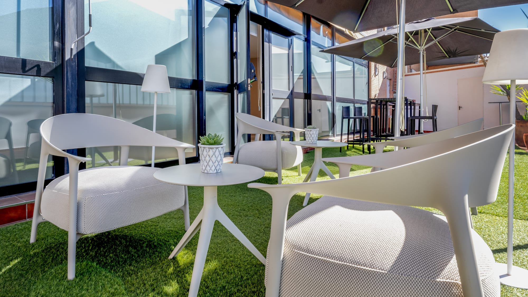 a patio area with chairs and umbrellas