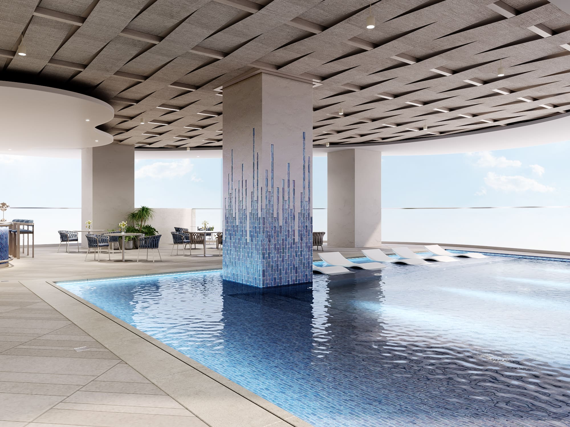 Luxury hotel pool deck with mosaic column, lounge chairs, and outdoor bar.