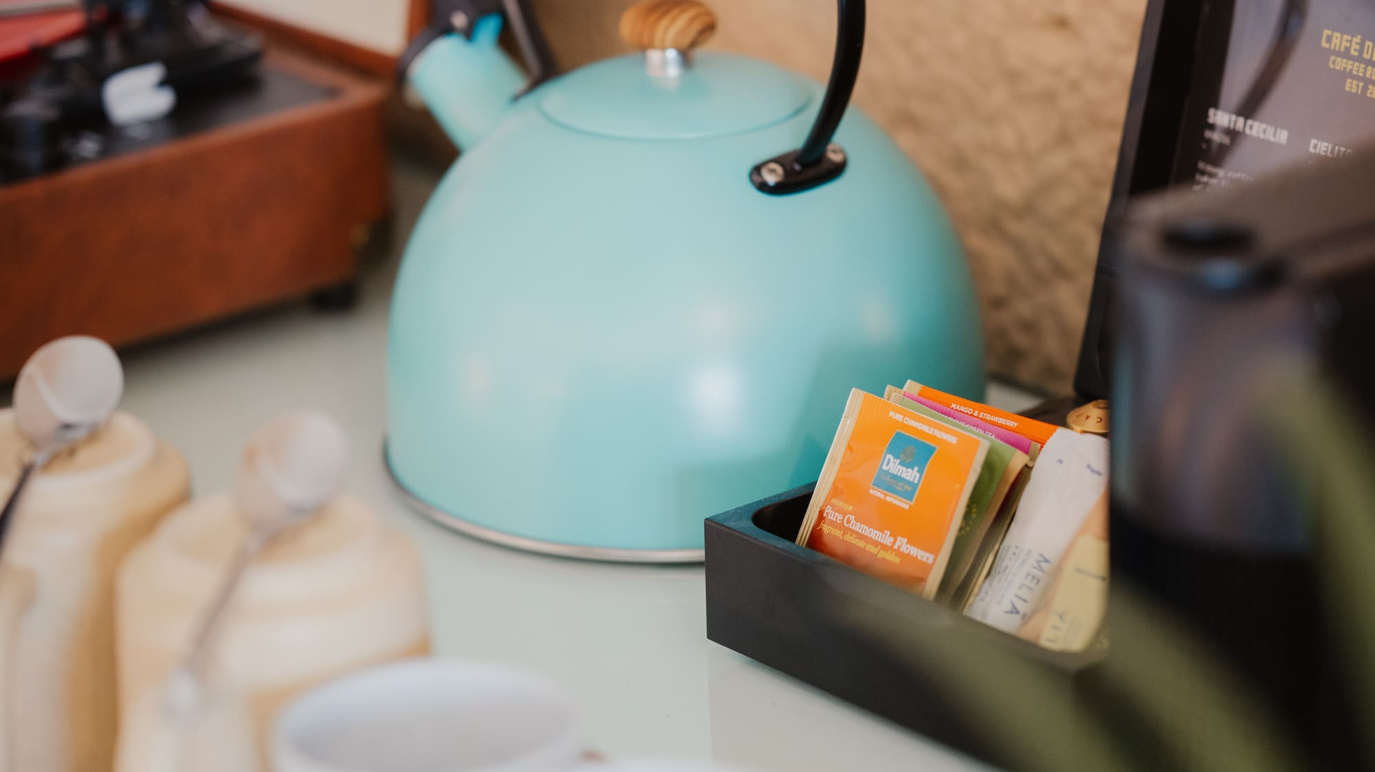 Turquoise kettle, tea/coffee station with mugs, vintage record player.