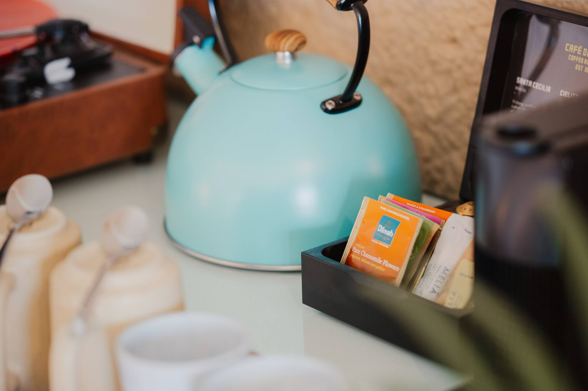 Turquoise kettle, tea/coffee station with mugs, vintage record player.