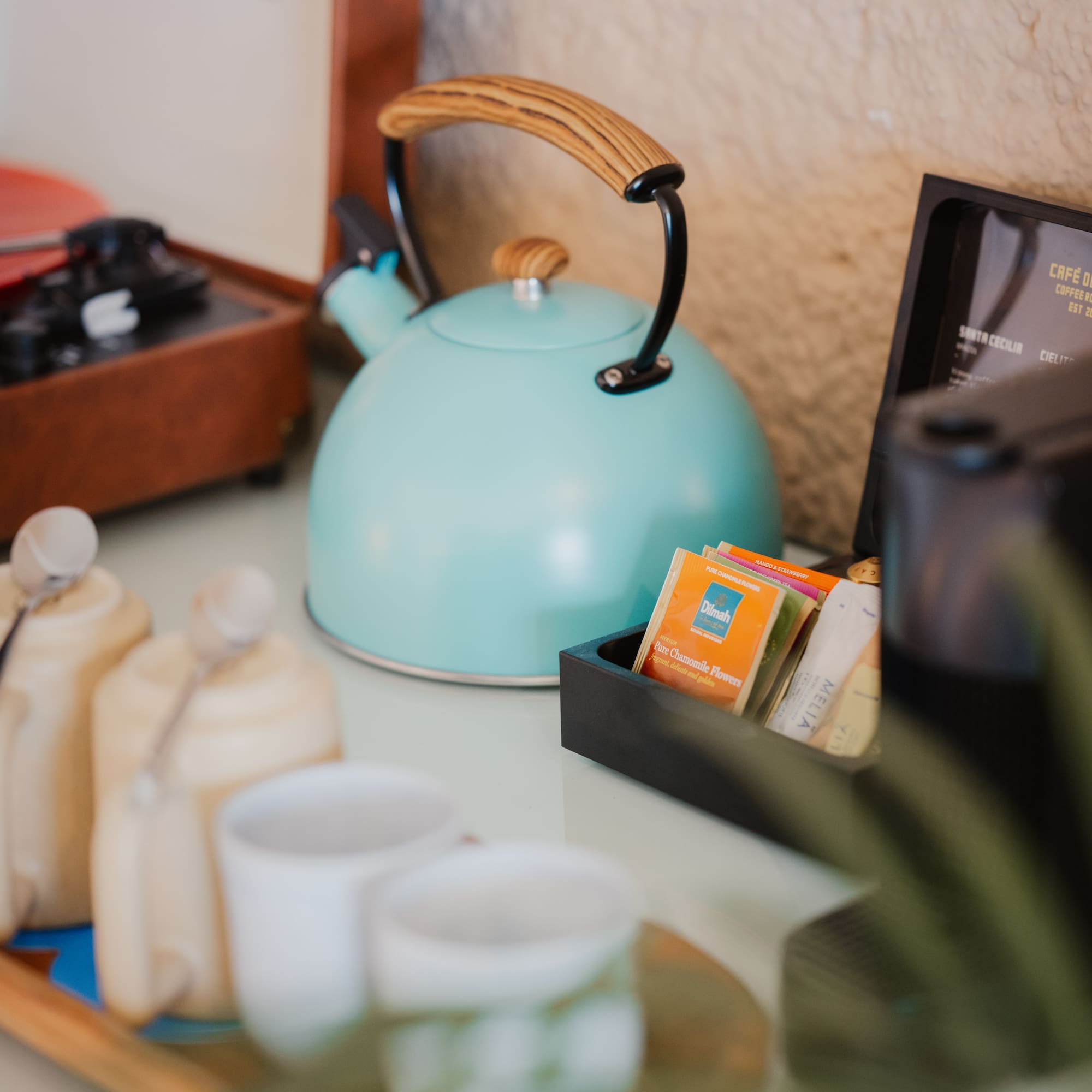 Turquoise kettle, tea/coffee station with mugs, vintage record player.