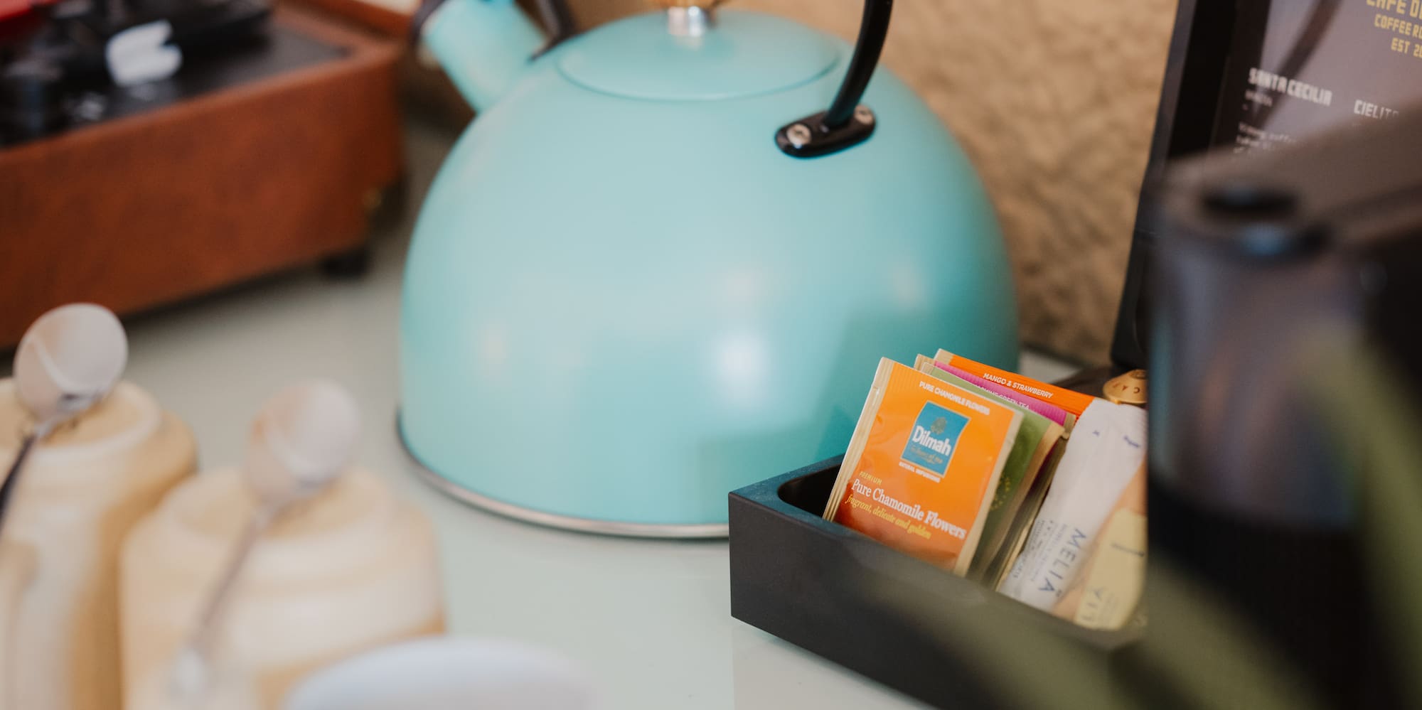 Turquoise kettle, tea/coffee station with mugs, vintage record player.