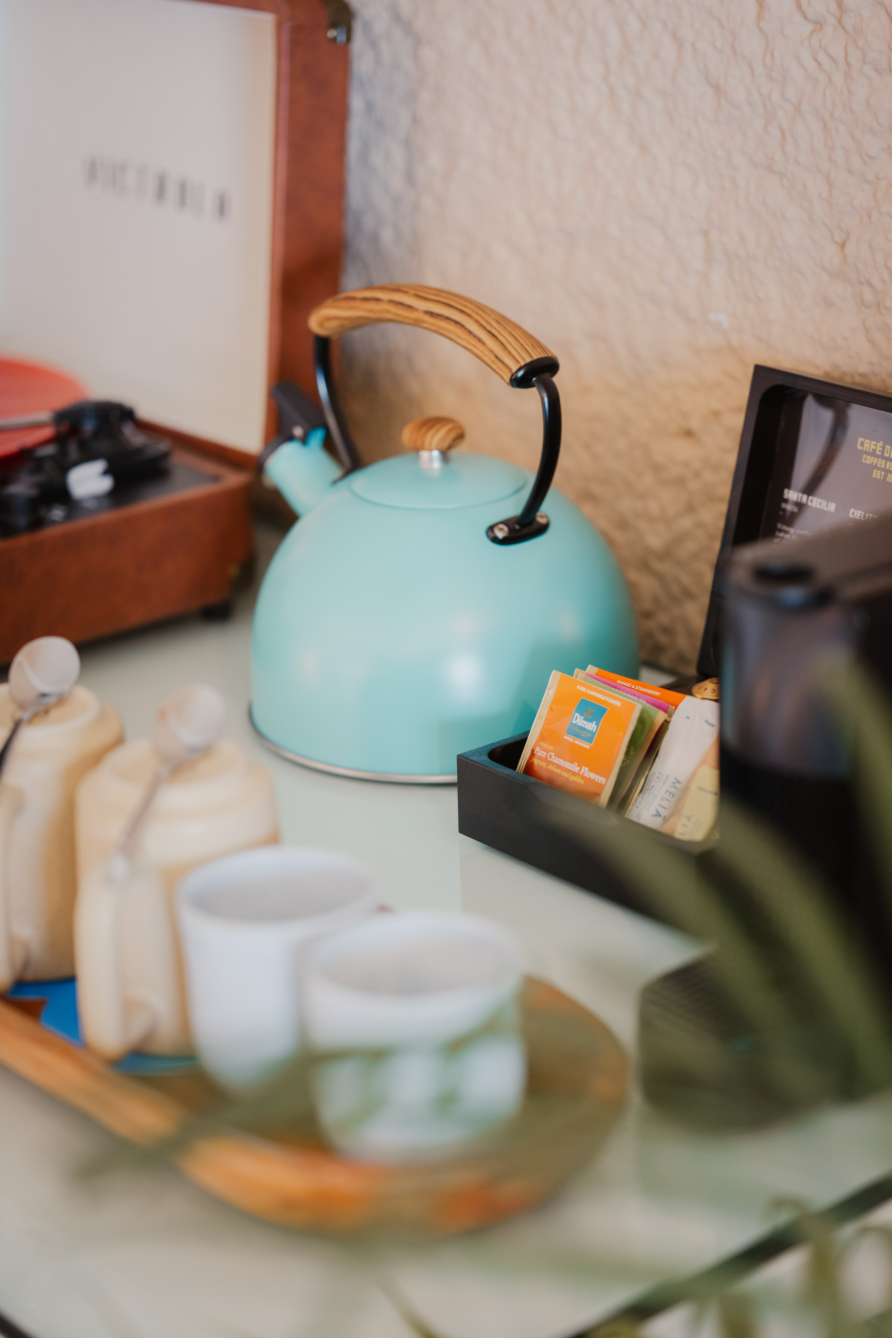 Turquoise kettle, tea/coffee station with mugs, vintage record player.