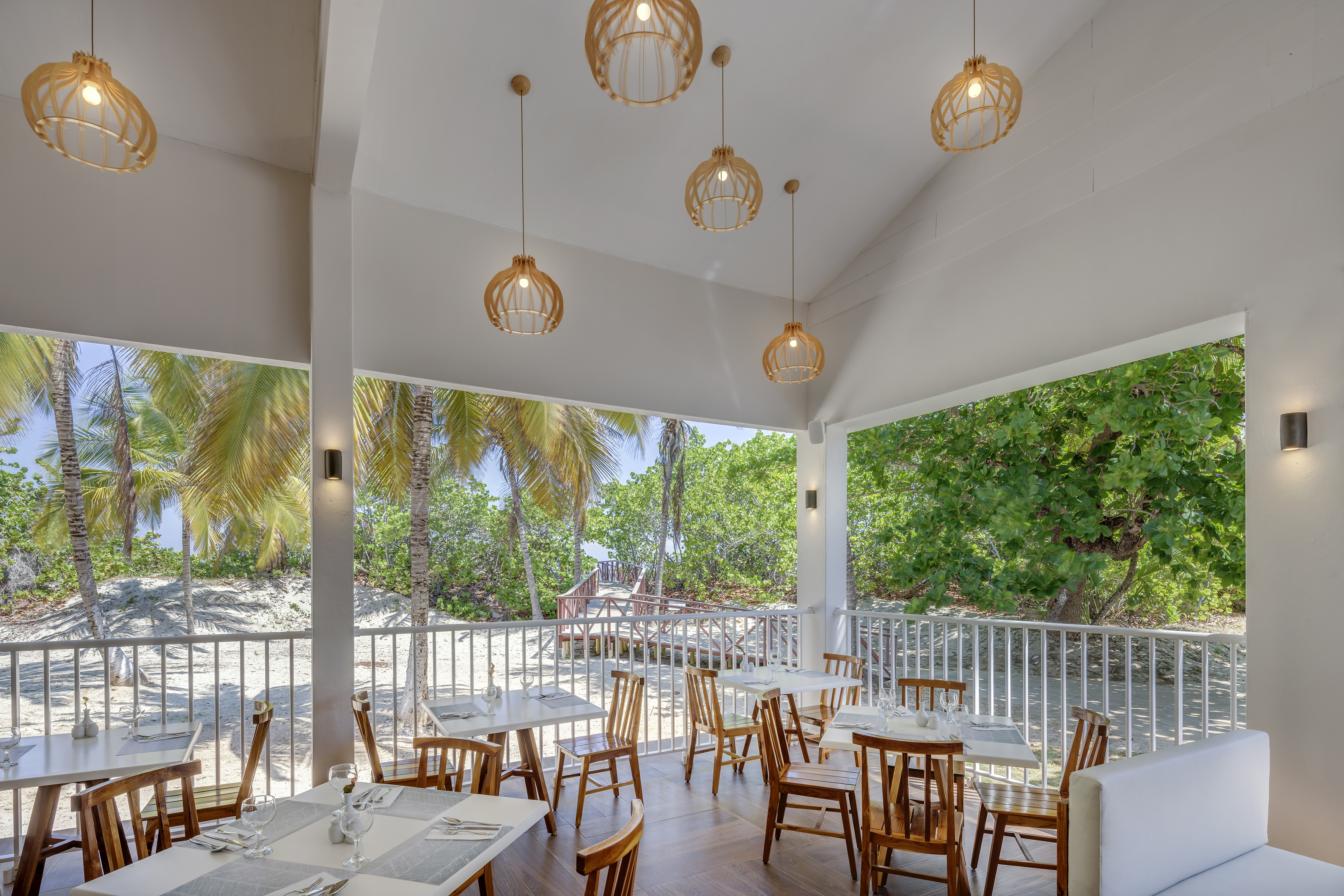 a room with tables and chairs and a white railing