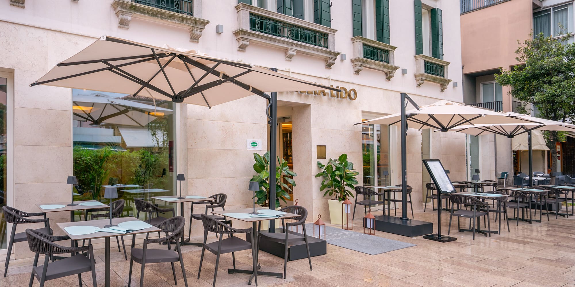 LIDO outdoor dining area with modern tables, chairs, and umbrellas.