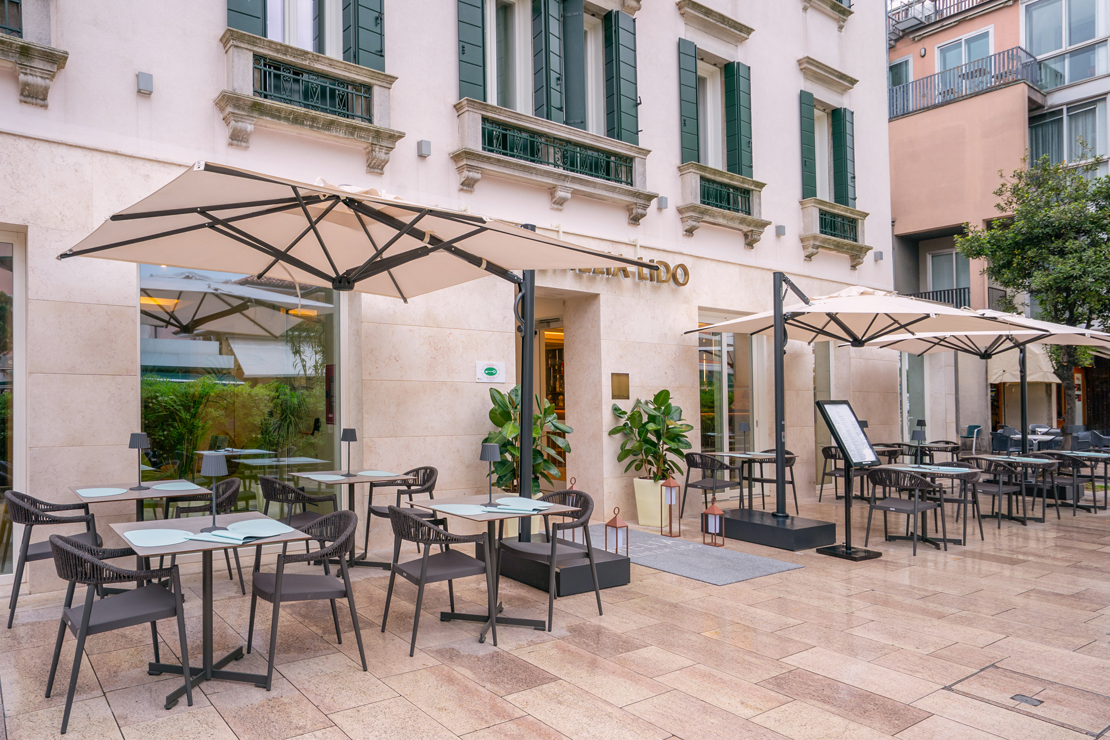 LIDO outdoor dining area with modern tables, chairs, and umbrellas.