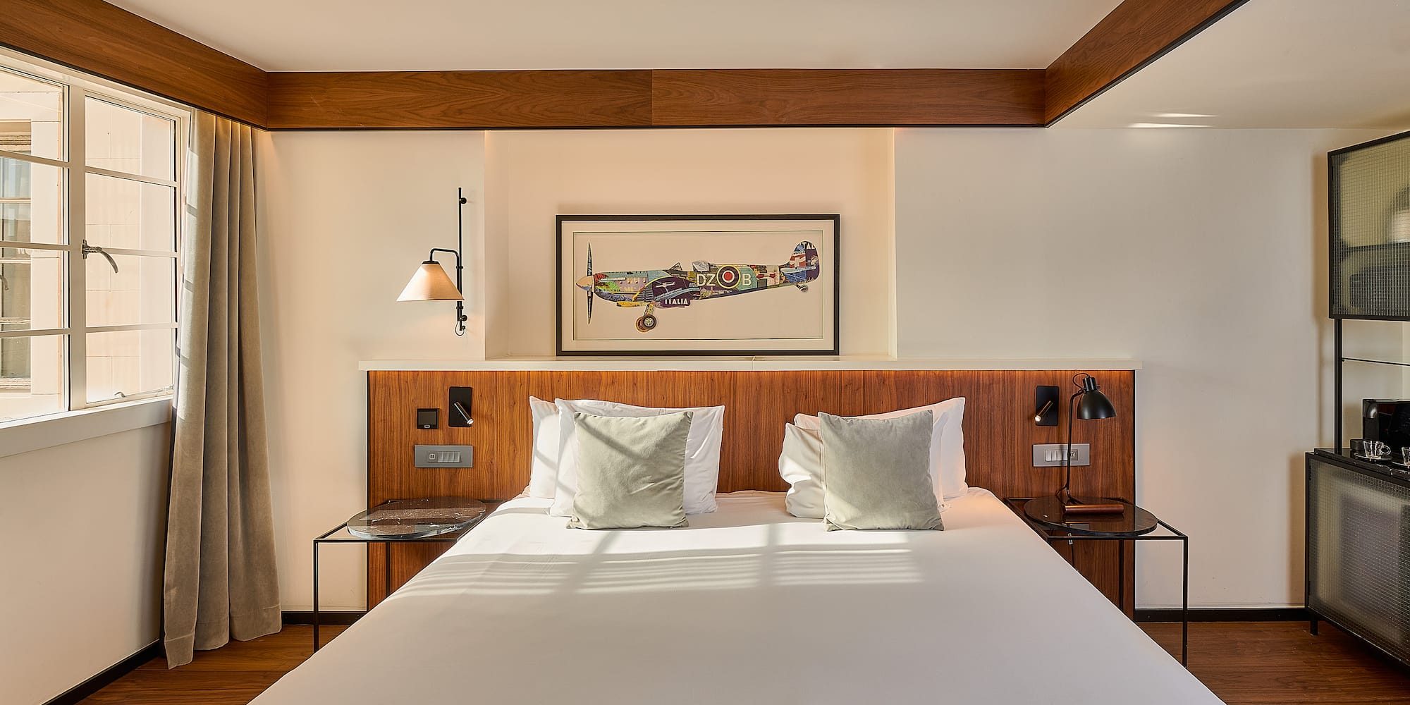 a bed with white sheets and pillows in a room