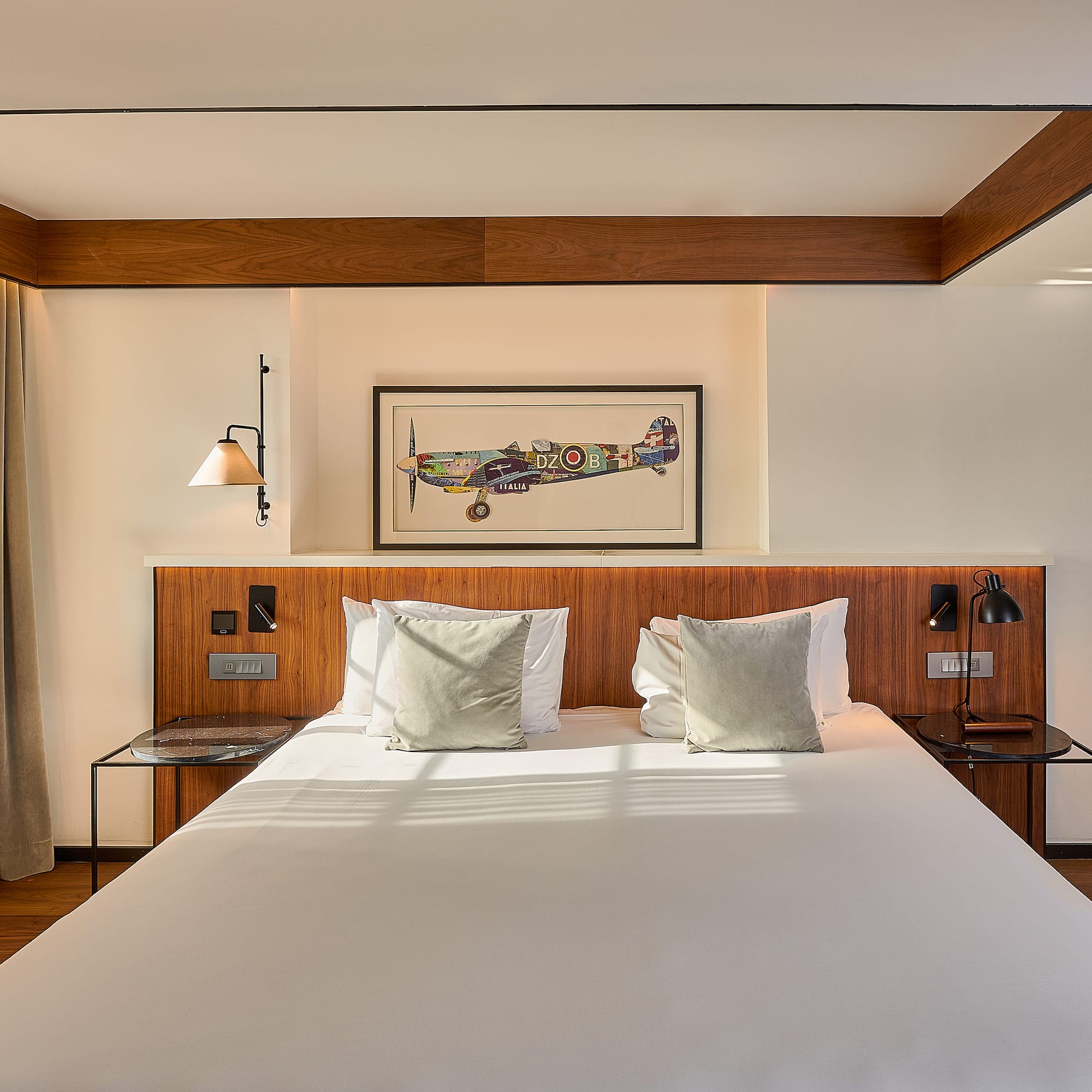 a bed with white sheets and pillows in a room