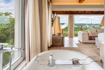 a bathroom with a tub and a large window