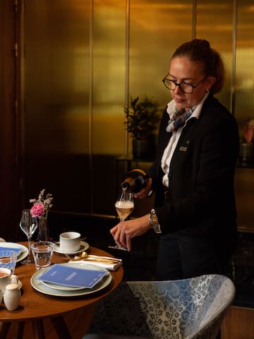 a woman pouring wine into a glass