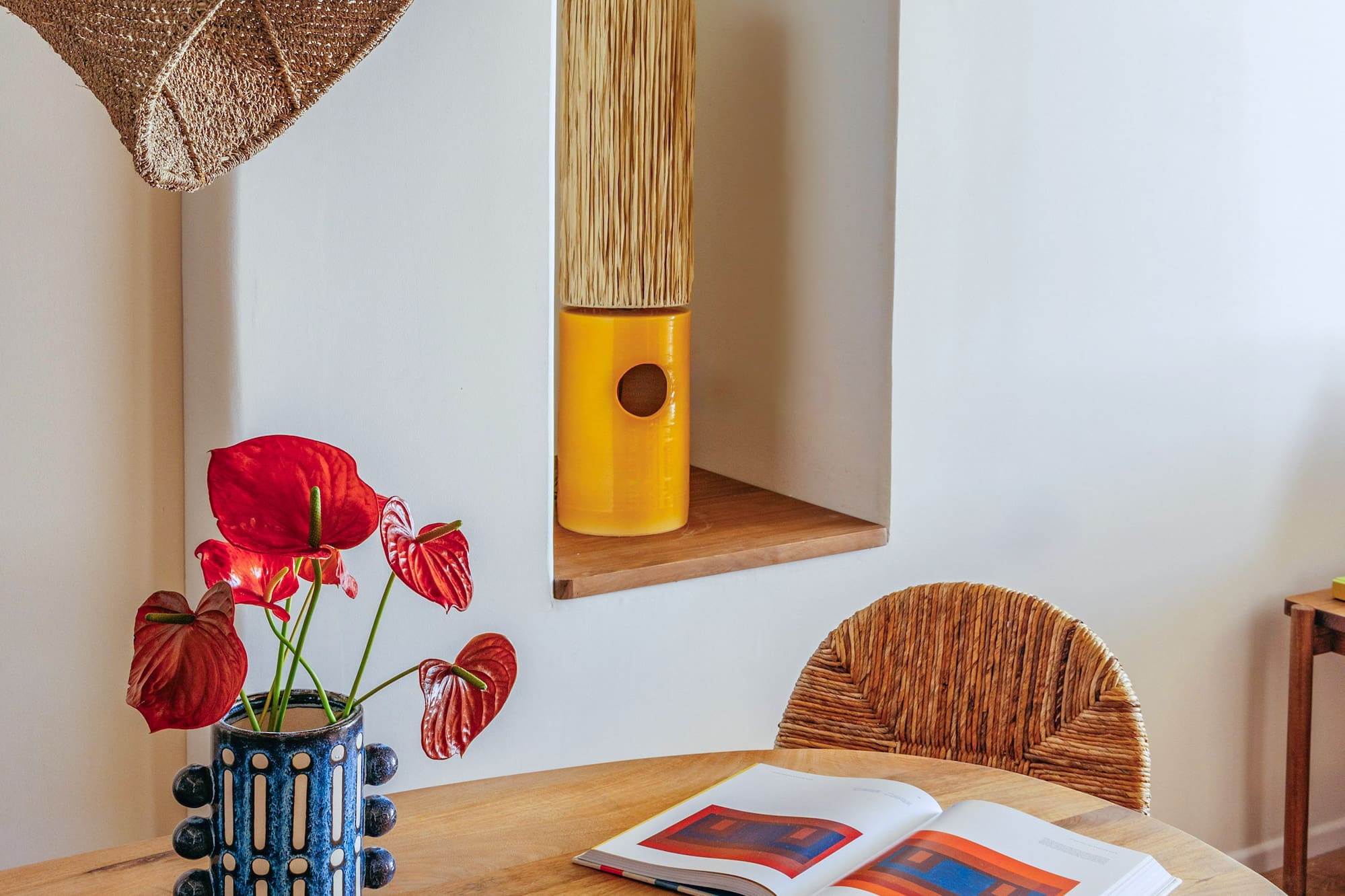 a table with a book and a vase of flowers on it